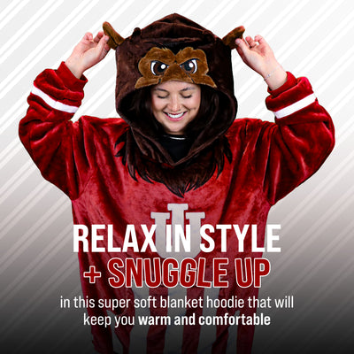 A person wearing a plush red and brown Bison mascot hooded blanket costume poses with hands on the hood ears against a gray diagonal-striped background. Large text reads 'RELAX IN STYLE + SNUGGLE UP' and smaller text below describes comfort.